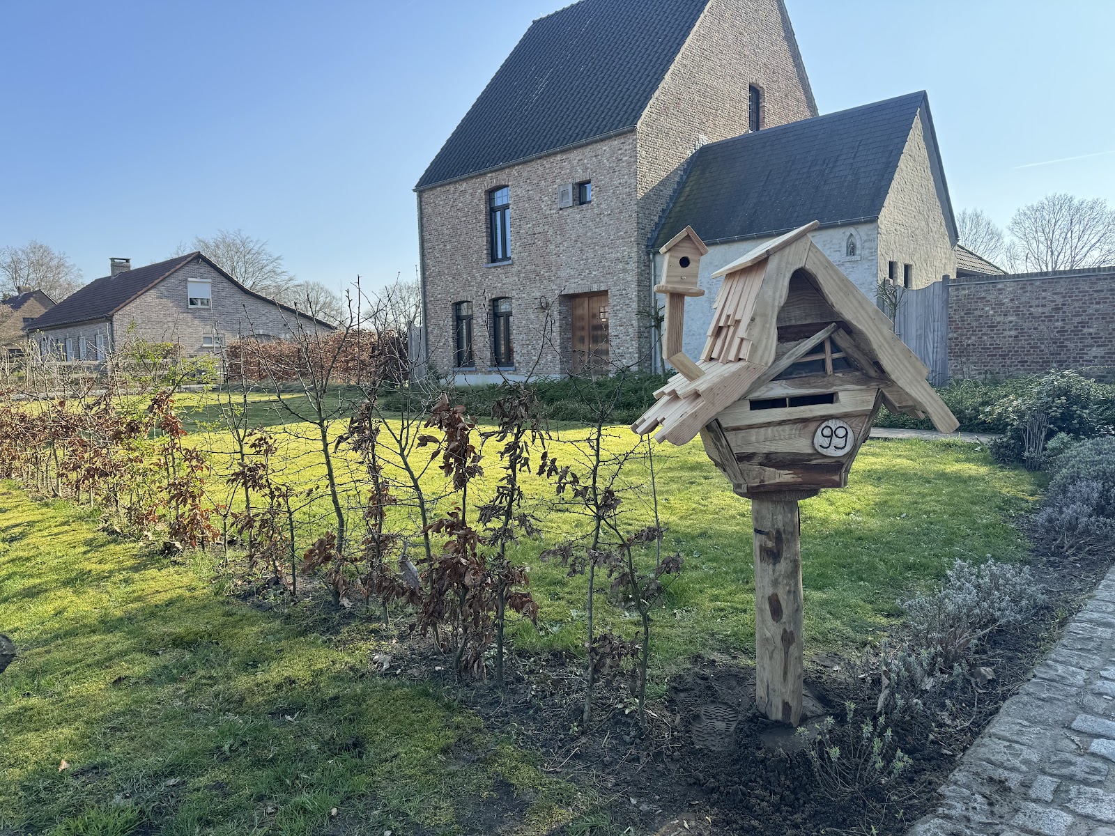 Handgemaakte houten brievenbus in een Kempense tuin